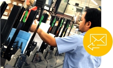 a worker sorts direct mail printed pieces on the J O factory floor